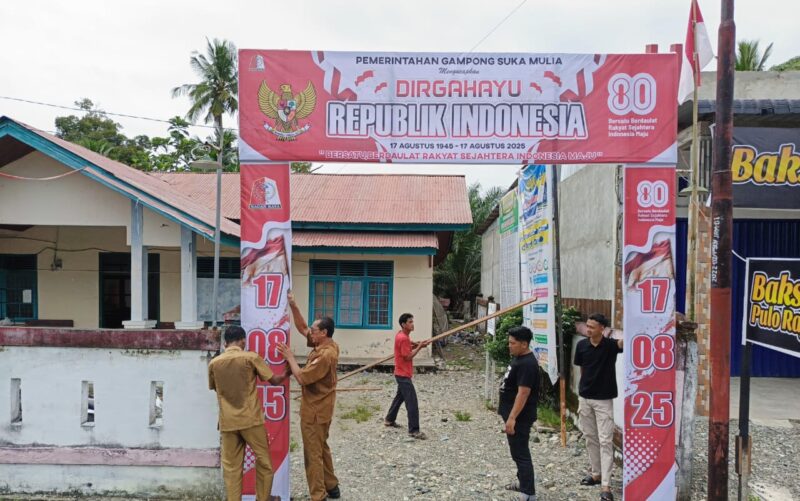 Ket foto : Warga bersama Aparatur Gampong Sukamulia bergotong royong melakukan pemasangan umbul-umbul dan baleho dalam rangka menyambut HUT RI ke-80, Senin (11/08/2025).